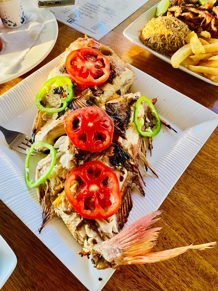 Whole grilled fish with tomatoes and peppers